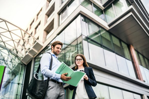 a-young-businessman-and-businesswoman-standing-in-LM5QHAS